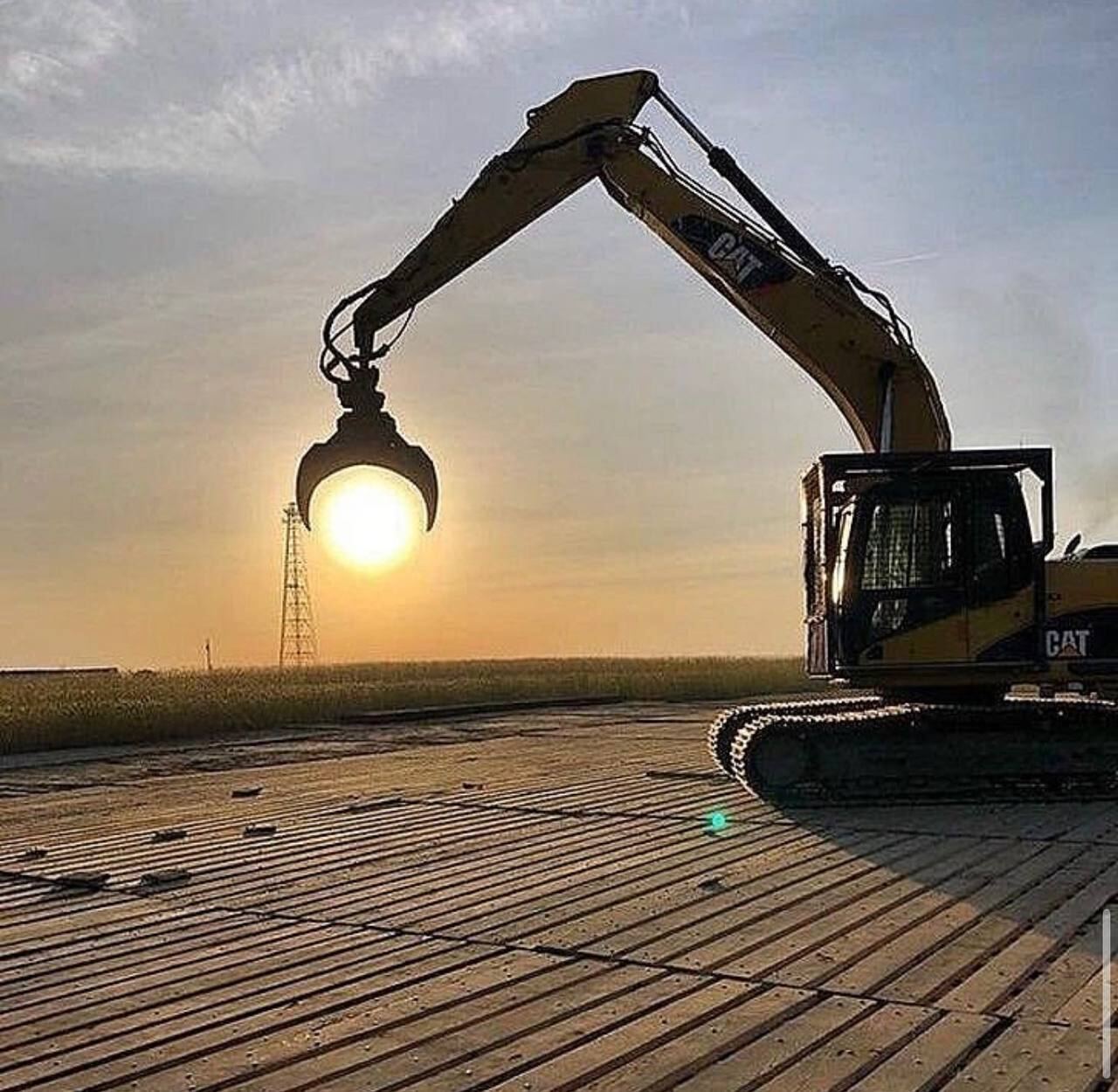 Excavator with grapple at sunset