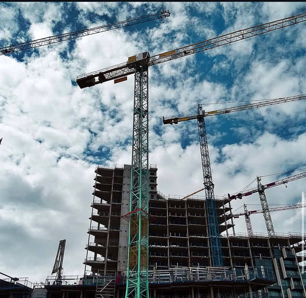 Tower cranes above a multi-storey concrete structure